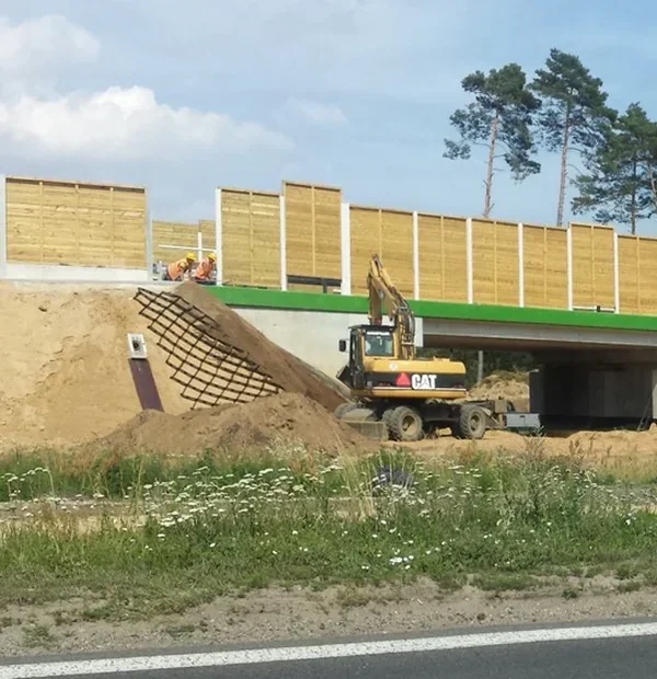 Zdjęcie skarpy stożka nasypu przy wiadukcie z koparką